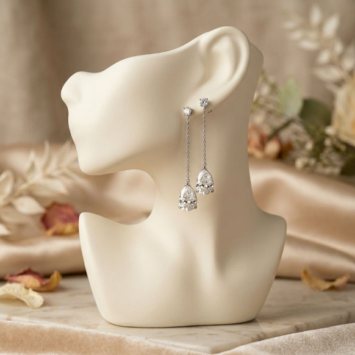 Pear-shaped diamond drop earrings styled for a round face.